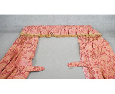 A pair of red and gold silk mix foliate design curtains with pelmet and tie backs. Silk tassel edging to the pelmet. L.220cm 