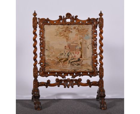 Victorian carved walnut fire screen, barley twist supports, inset with a woolwork panel, scrolled legs, width 74cm, height 92