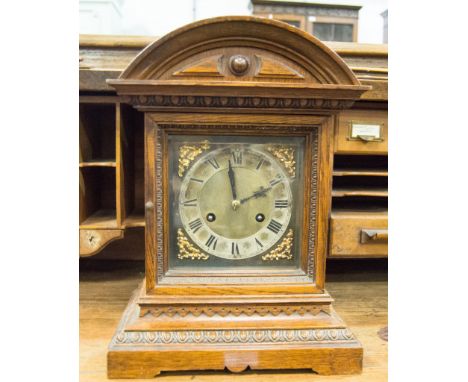 Oak mantel clock with architectural pediment, Roman chapter ring with brass spandrels, twin train movement striking on a gong