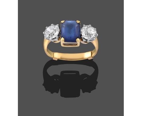 A Diamond and Blue Paste Three Stone Ring, the emerald-cut blue paste in yellow claw settings, flanked by two old cut diamond