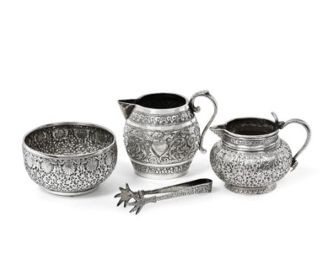 Two Indian Silver Cream-Jugs and a Sugar-Bowl, Apparently Unmarked, Late 19th Century, the cream-jugs each repoussé and chase