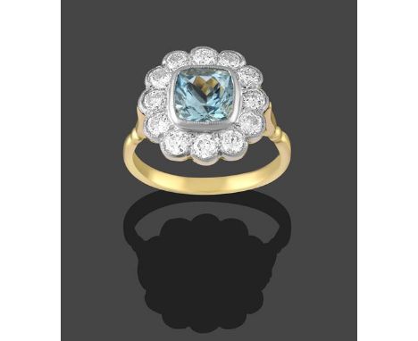 An Aquamarine and Diamond Cluster Ring, the cushion cut aquamarine within a border of round brilliant cut diamonds, in white 