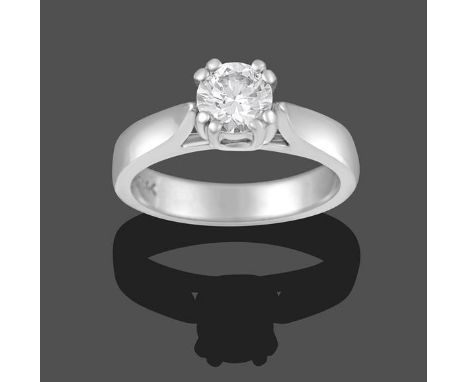 A Diamond Solitaire Ring, the round brilliant cut diamond in a white claw setting, to a tapered shoulder plain polished shank
