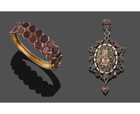 A 19th Century Garnet Bangle, closed set with oval shaped foiled garnets, graduated from the centre in two rows interspaced w