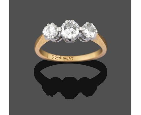 A Diamond Three Stone Ring, the graduated round brilliant cut diamonds in white double claw settings, on a yellow tapered sho