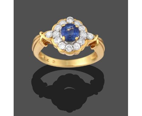 A Sapphire and Diamond Cluster Ring, the round cut sapphire in a yellow claw setting, within a border of round brilliant cut 