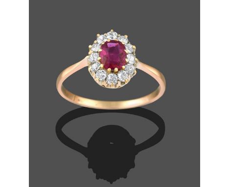 A Ruby and Diamond Cluster Ring, the oval cut ruby within a border of old cut diamonds, in yellow claw settings, to a tapered