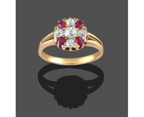 A Ruby and Diamond Cluster Ring, the old cut diamond within a border of old cut diamonds and cushion cut rubies, in yellow cl