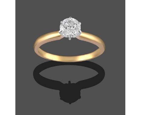 A Diamond Solitaire Ring, the round brilliant cut diamond in a white claw setting, on a yellow tapered shoulder plain polishe