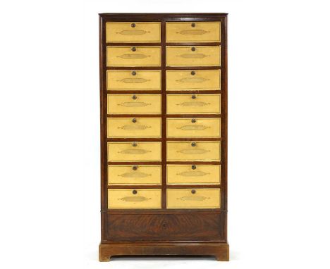 A French mahogany chest of seventeen drawers, early 20th century, having sixteen short drawers with cardboard inserts, over a