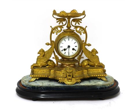 A French gilt spelter mantel clock, 19th century, the enamel dial within crouched griffins, a tazza and scrolls, the shaped b