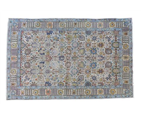 A Persian Tabriz carpet , c.1920, the field with repeating floral and foliate motifs on a cream ground, 316 x 222cm