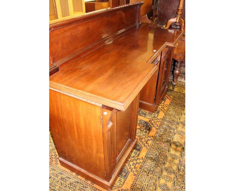 An early Victorian mahogany ledgeback inverted breakfront pedestal sideboard having single central frieze drawer, flanked by 
