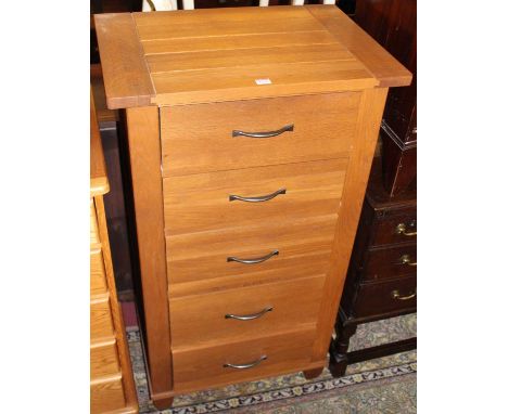 A contemporary light oak narrow chest of five long drawers, width 68cm