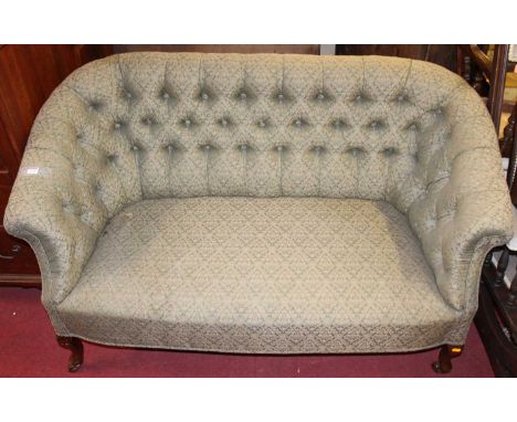 A Victorian green floral button back upholstered two seat parlour sofa, raised on squat cabriole forelegs to castors, width 1