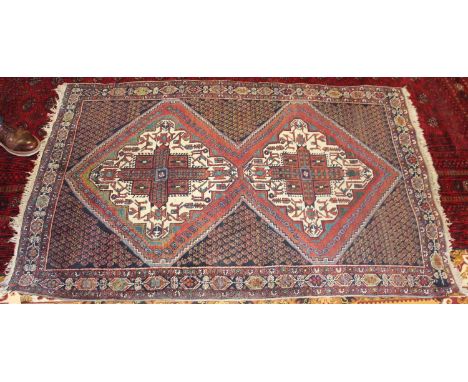 A Turkish woollen rug, the blue ground decorated with two lozenge medallions within trailing tramline borders (some wear), 10