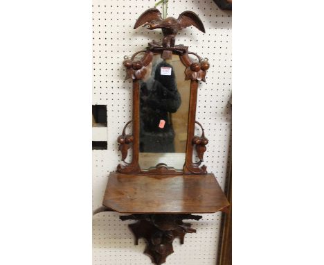 A circa 1900 carved oak mirrored wall shelf having eagle surmounts, height 90cm