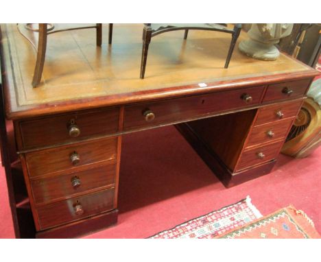 A Victorian mahogany and gilt tooled tan leather inset twin pedestal partners desk, having an arrangement of nine drawers opp