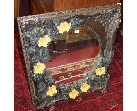A heavily floral decorated gesso moulded rectangular wall mirror, the mirror plate housed as an oval (with some losses) 83.5 