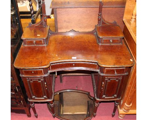A circa 1900 French mahognay kneehole shield shaped swing mirror back dressing table, having edged brass detail and three fri