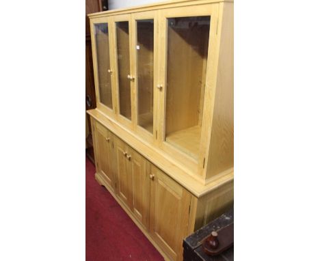 A contemporary light elm side cabinet, having four glazed upper doors with adjustable panelled shelves over four conforming r