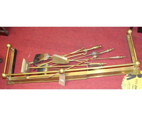 A late Victorian brass curb fender, together with various similar fire tools on stand