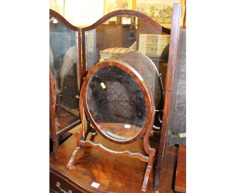 An early 20th century mahogany triptych dressing mirror, together with a further 19th century mahogany oval swing dressing mi