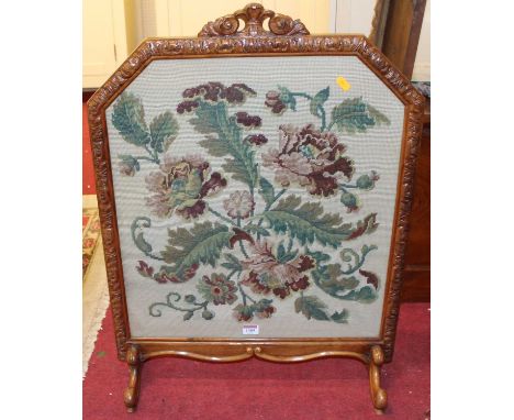 A figured walnut framed and floral tapestry embroidered fire screen having carved floral surmount, width 56.5cm