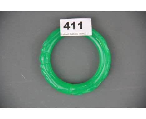 A Chinese carved green jade/hardstone bangle decorated with two dragons, internal Dia. 6cm.