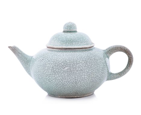 A SMALL CELADON TEAPOT Globular-squat shape, with domed and knop lid, ring handle 6.5cm high Condition: Minor glaze loss to e