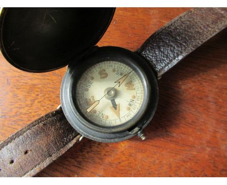 A World War Two wrist compass, with black metal hunter style case, on a leather strap