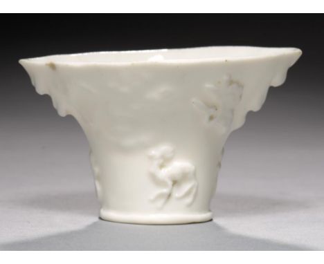 A BLANC DE CHINE LIBATION CUP, QING DYNASTY, KANGXI PERIOD  of rhinocerous horn form, moulded with qilin and phoenix, 6cm h++