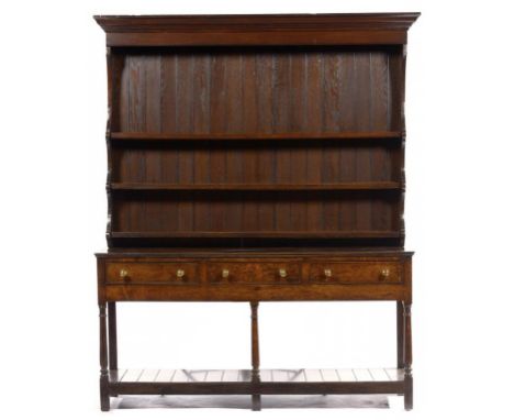 AN OAK DRESSER, 19TH C the boarded three shelf rack with moulded cornice, the base fitted three cockbeaded drawers, on turned