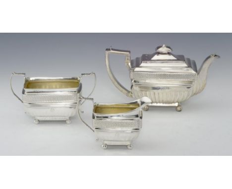 A GEORGE III MATCHED SILVER TEA SERVICE of fluted oblong shape with integral hinge to the teapot lid, crested, teapot 15cm h,