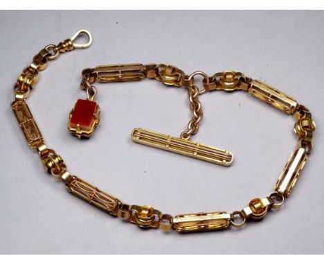 A yellow metal fancy link watch chain - tests as 14ct, with an arrangement of rectangular open links joined by discs, with a 