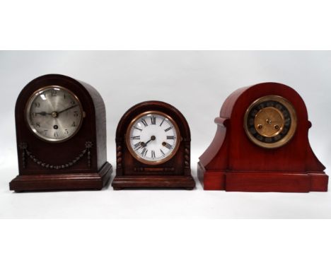 A 20th century oak cased mantel clock - the arched case with applied swags, the silvered dial set out in Arabic numerals and 