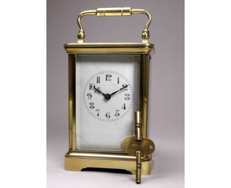 An early 20th century carriage clock - in a brass corniche case, the white enamel dial set out in Arabic numerals and fitted 