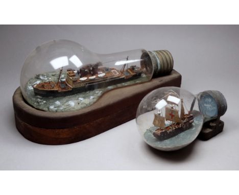 Ship in a light bulb, 20th century - the un-named motor vessel in a calm sea, length 25cm, together with a similar smaller of