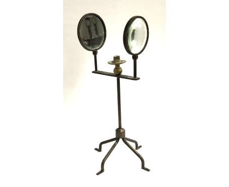 An unusual lighting device, having a candle nozzle flanked by a mirror and a lens, 63cm high 