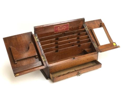 An early 20th century oak stationery box, opening to a letter rack, embossed leather plaque reading 'presented to Mr F S Jone