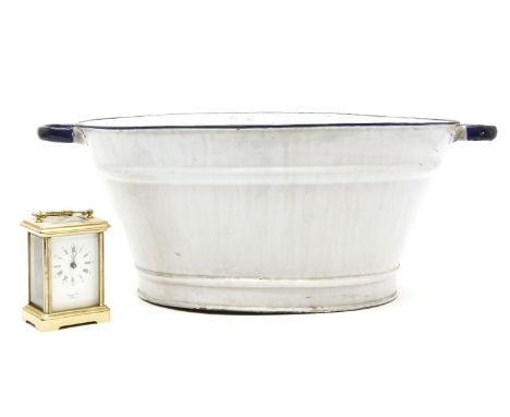 A brass carriage clock and an enamel twin handled bowl