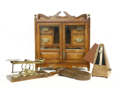 An Edwardian smoker's cabinet, a metronome, par of brass postal scales, and a wooden rattle