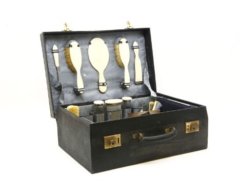 A blue leather dressing case, silver mounted, London, 1926, with ivory tops and backs, 50cm wide