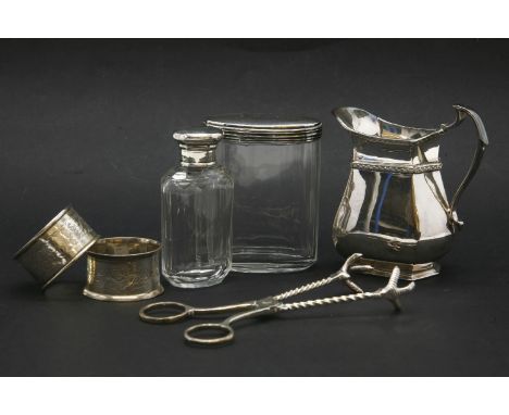 Silver topped cut glass bottles, a plated Harrod’s jug and two silver napkin ring and sugar tongs