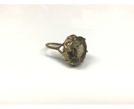 9ct gold smoky quartz cocktail ring with an oval mixed cut smoky quartz in claw setting with carved leaf design gallery on go