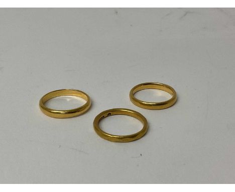 Three 22ct gold wedding bands, ring sizes J 1/2, K and M1/2 (3) 9.4 grams total gross weight