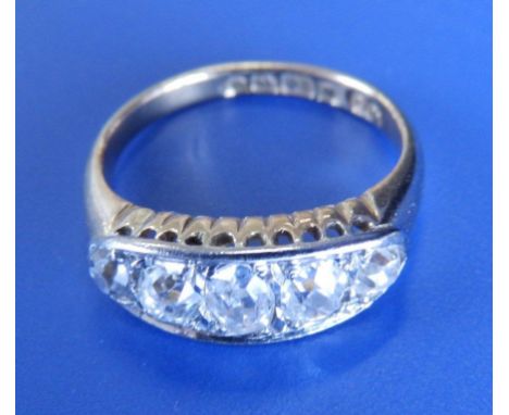 A five stone graduated diamond ring, the central old cut stone weighing approximately .50 carat in white metal setting on 18c