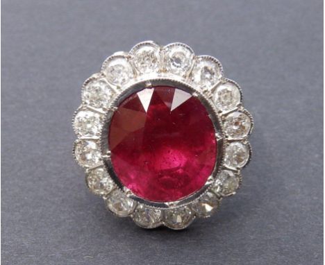 A large ruby &amp; diamond cluster ring, the collet set oval cut pigeon-blood ruby weighing approximately 9 carats in white m