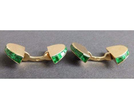 A cased pair of early 20thC Cartier emerald set 18ct yellow gold cufflinks, of semi-circular design calibre set emeralds, eac