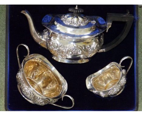 An Edwardian cased silver three piece silver tea service, of London shape embossed flowers and scrolls – JG Ltd, Birmingham  